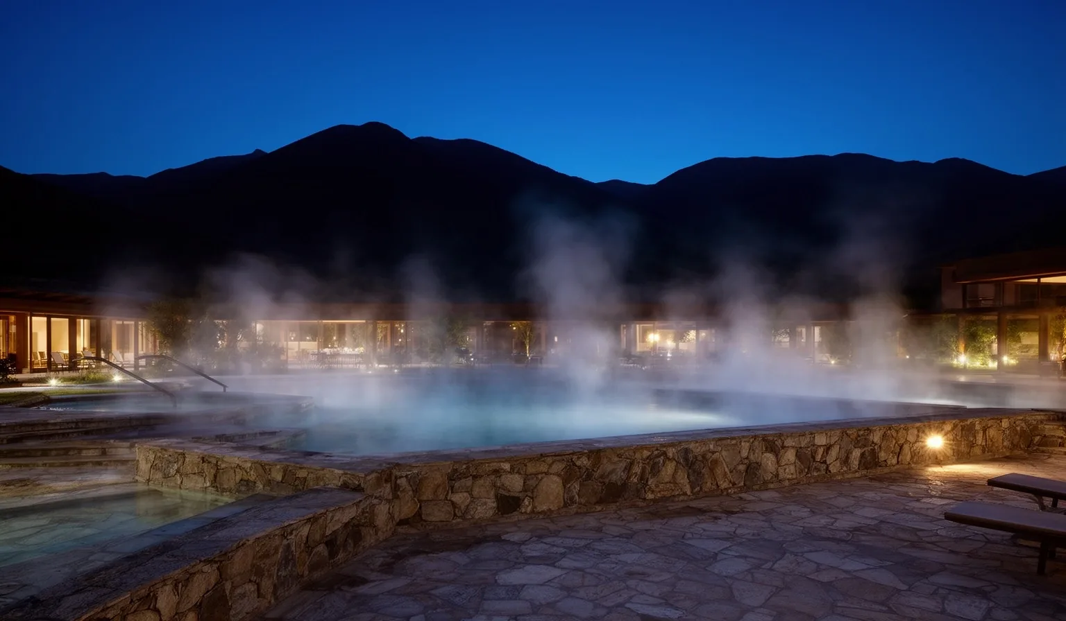 Complejo termal argentino al atardecer con vapor sobre aguas minerales